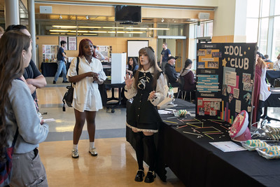 Raina_IdolClub students gather around table advertising the Idol Club