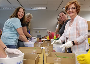 students in cce course with gloved hands in buckets
