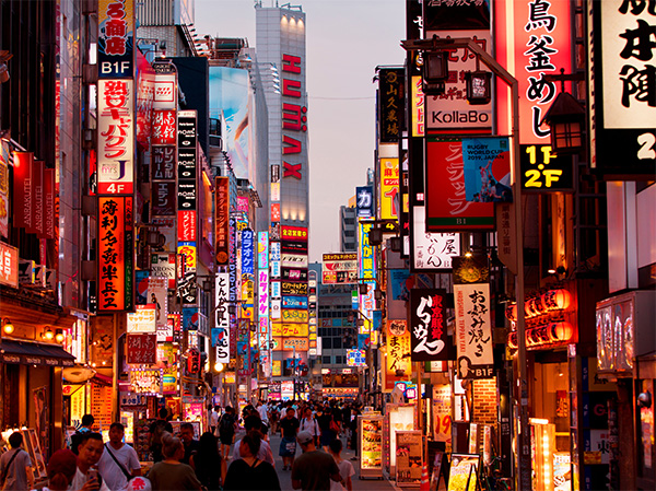 crowd of people on tokyo street at twilight walk under lighted signs