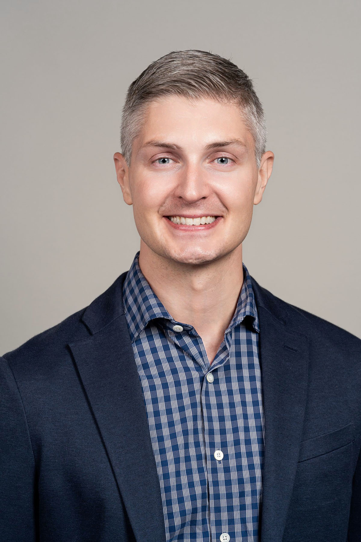 man with blue eyes wearing blue plaid shirt and suit jacket