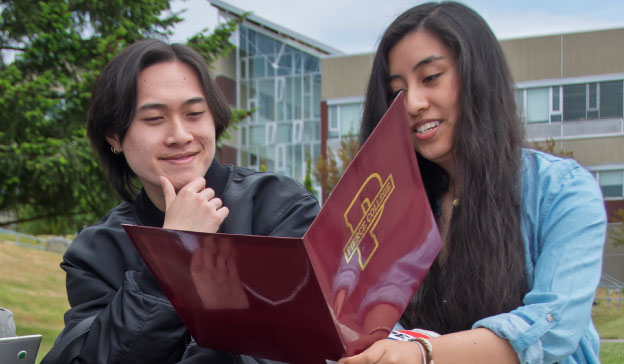 Two students collaborating outside on campus
