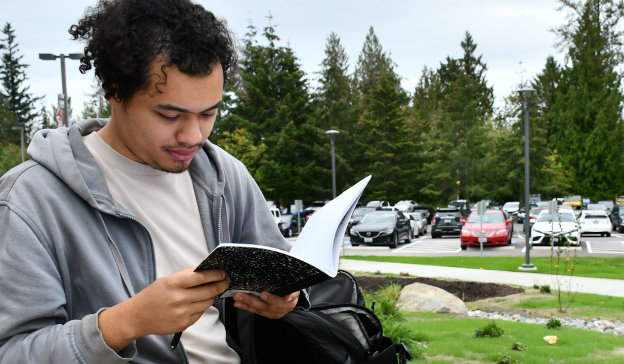 student reading book outdoors