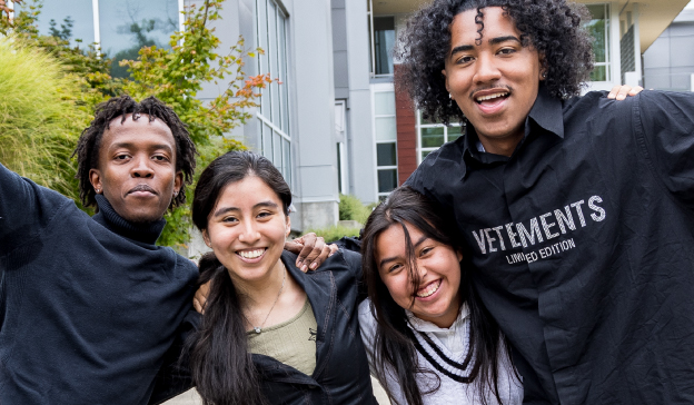 A group of four students celebrating outdoors